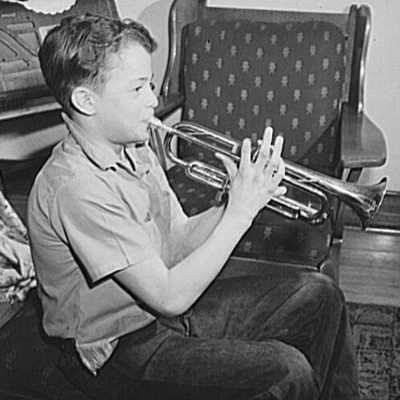 young bou playing trumpet in black and white photo
