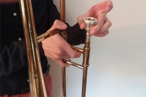 trombone mouthpiece being inserted into slide section