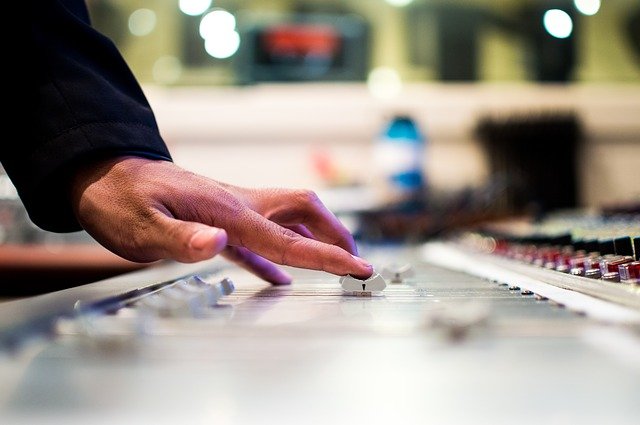 Hand on studio mixing board
