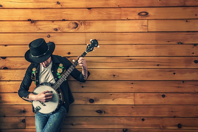 man with used banjo on wood wall